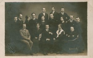 E. Lorson. Stasys Šalkauskis tarp kitų lietuvių studentų. Pirmoje eilėje iš kairės: Kazys Pakštas, Marija Andziulytė-Ruginienė, Vincas Mykolaitis-Putinas, Ona Vosyliūtė-Pakštienė, Edvardas Turauskas. Antroje eilėje antras iš kairės Stasys Šalkauskis, U. Urniežiutė-Starkienė, Izidorius Tamošaitis, M. Ambraziejūtė-Kondrotienė, H. Žilevičius, O. Petrauskaitė-Krikščiūnienė, Pranas Jucaitis, J. Navickas. Trečioje eilėje L. Bistras, V. Raulinaitis, K. Ruginis. Fribūras (Šveicarija). 1918 m. Maironio lietuvių literatūros muziejus. Naudojimo teisės: PD. Nuotrauka iš Europeanos