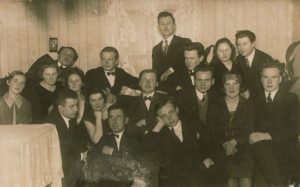 Antanas Miškinis (sėdi centre, ranka parsirėmęs), rašytoja Petronėlė Otintaitė (trečia iš kairės), poetas, dramaturgas Kazys Inčiūra (viršuje, antras iš kairės) ir kiti Lietuvos universiteto studentai svečiuose pas kolegą Henriką Blazą. Apie 1926–1927 m. Maironio lietuvių literatūros muziejus. Naudojimo teisės: PD. Nuotrauka iš Europeanos