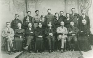 Vilniaus lietuvių vyrų gimnazija. Sėdi pedagogai (trečias iš kairės M. Šikšnys, ketvirtas V. Biržiška), stovi mokiniai. Vilnius. 1921 m. Lietuvos nacionalinis dailės muziejus. Naudojimo teisės: PD. Nuotrauka iš Europeanos