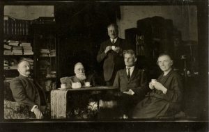 Mykolas Šleževičius darbo kabinete su Jonu Basnavičiumi, Kaziu Griniumi, Felicija Bortkevičiene, Tomu Naruševičiumi. [1926].II.24. Lietuvos nacionalinė Martyno Mažvydo biblioteka. Naudojimo teisės: PD. Nuotrauka iš Europeanos