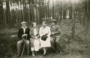 Išėję pasivaikščioti po pušyną šalia savo vasarnamio Valakampiuose ant suoliuko sėdi: iš kairės pirmas – Jurgis Šlapelis, šalia jo – Marija Šlapelienė. 1932 m. Marijos ir Jurgio Šlapelių namas-muziejus. Naudojimo teisės: PD. Nuotrauka iš Europeanos