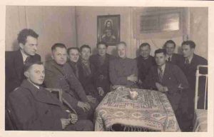 Julius Miežlaiškis. Radiofono orkestro direktorius, kompozitorius Balys Dvarionas (pirmas iš kairės už sėdinčiųjų), Šaulių sąjungos kultūros ir švietimo skyriaus viršininkas Vincas Daugvardas, rašytojas Petras Babickas (centre galustalėje) ir kiti Šaulių sąjungos aktyvistai susitikime su Vilniaus krašto žmonėmis. 1939 m. Maironio lietuvių literatūros muziejus. Naudojimo teisės: PD. Nuotrauka iš Europeanos