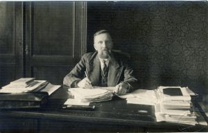 Ekonominės karių bendrovės fotoateljė. Liudas Gira savo kabinete Švietimo ministerijoje. 1936–1937 m. MLLM F 20. Maironio lietuvių literatūros muziejus. Naudojimo teisės: PD. Nuotrauka iš LIMIS