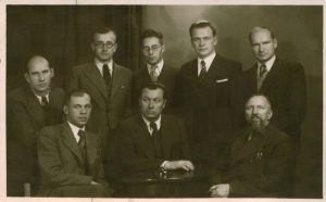 Mejeris Smečechauskas. Lietuvos rašytojų draugijos valdybos nariai (iš kairės (sėdi): Juozas Ambrazevičius- Brazaitis, Juozas Grušas, Liudas Gira; stovi: Stasys Santvaras, Antanas Vaičiulaitis, Kostas Korsakas, Kazys Inčiūra, Benediktas Rutkauskas-Rutkūnas. 1938 m. Maironio lietuvių literatūros muziejus. Naudojimo teisės: PD. Nuotrauka iš Europeanos