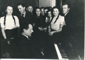 B. Dvarionas su grupe dainininkų radijo studijoje. KMM FP 221. Kauno miesto muziejus. Naudojimo teisės: CC BY-NC. Nuotrauka iš LIMIS