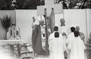 Edmundas Katinas. Popiežiaus Jono Pauliaus II vizitas Kaune. Popiežius Jonas Paulius II laimina susirinkusius tikinčiuosius Santakos parke. 1993 m. Kauno IX forto muziejus. Naudojimo teisės: CC BY-NC. Nuotrauka iš Europeanos