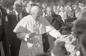 Edmundas Katinas. Popiežiaus Jono Pauliaus II vizitas Kaune. Popiežius eidamas link altoriaus įrengto Santakos parke, laimina į susitikimą atsineštą vaiką. 1993 m. Kauno IX forto muziejus. Naudojimo teisės: CC BY-NC. Nuotrauka iš Europeanos