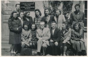 Profesorius V.Mykolaitis-Putinas sėdi su studentais Vilniaus valstybinio universiteto Istorijos ir Filologijos fakulteto kiemelyje. 1947 m. MLLM F3 693. Maironio lietuvių literatūros muziejus. Naudojimo teisės: PD. Nuotrauka iš LIMIS