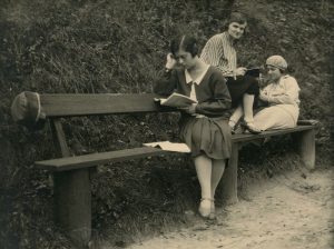 Gražutė ir Laimutė Šlapelytės su drauge mokosi Gedimino kalno papėdėje. Pirma iš kairės sėdi Gražutė, antra – E. Valterytė, trečia – Laimutė Šlapelytė. 1928 m. Marijos ir Jurgio Šlapelių namas-muziejus. Naudojimo teisės: PD. Nuotrauka iš Europeanos