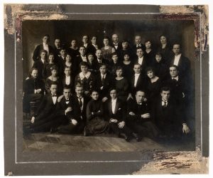 Operos „Traviata“ valdyba ir atlikėjai. Iš kairės: pirmoje eilėje antras choristas Petras Martinaitis, penktas solistas Jonas Byra, paskutinis Antanas Lanka (?); antroje eilėje Stasys Šilingas, trečias choro dirigentas Julius Štarka, solistai Vladislava Grigaitienė, Kipras Petrauskas, Adelė Galaunienė, dirigentas Juozas Tallat-Kelpša, paskutinis režisierius Konstantinas Glinskis; trečioje eilėje choristas Antanas Dvarionas, solistė Julija Dvarionaitė, penktas solistas Petras Oleka, septintas muzikas Juozas Žilevičius, dešimtas solistas Juozas Bieliūnas, paskutinis solistas Aleksandras Kačanauskas. 1921 m. LNM ATV 19940. Lietuvos nacionalinis muziejus. Naudojimo teisės: CC BY. Nuotrauka iš LIMIS