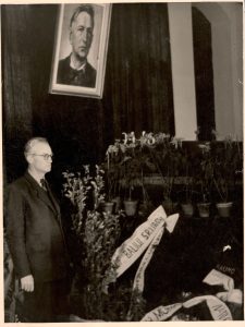 Atsisveikinimas su Baliu Sruoga. Vilnius, Lietuvos TSR rašytojų sąjunga, 1947 m. spalio 17 arba18 d. Prie karsto stovi rašytojas Vincas Mykolaitis-Putinas, pokario metais artimai bendravęs su Baliu Sruoga. 1947 m. MLLM F5 133. Maironio lietuvių literatūros muziejus. Naudojimo teisės: PD. Nuotrauka iš LIMIS
