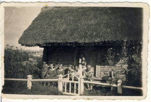 Rašytojas Antanas Žukauskas-Vienuolis su artimaisiais prie poeto Antano Baranausko klėtelės Anykščiuose. Iš dešinės: Antanas Žukauskas-Vienuolis, sūnus Stasys Žukauskas, žmona Leokadija Žukauskienė, poeto Antano Baranausko brolio Anupro dukterys Baranauskaitės, prie durų stovi dukra Laima Žukauskaitė. Apie 1931 m. VŽM F 724. A. Baranausko ir A. Vienuolio-Žukausko memorialinis muziejus. Naudojimo teisės: PD. Nuotrauka iš LIMIS