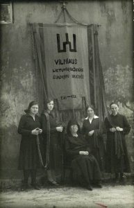 Vilniaus lietuvių Šv. Mikalojaus bažnyčios vėliava, išausta Emilijos Vileišienės iniciatyva, minint 25-ąsias šios bažnyčios atkovojimo sukaktuves. Sėdi Emilija Vileišienė, stovi – audėjos. 1926 m. Naudojimo teisės: PD. Nuotrauka iš Vikipedijos