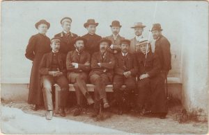 Nežinomas XX a. I p. fotografas. Jonas Jablonskis su kalbininkais ir kunigais 1909 m. Seinuose. Sėdi: Kazimieras Būga, Jurgis Šlapelis, Jonas Jablonskis, Kazimieras Jokantas, kun. Juozas Laukaitis, stovi: kun. Antanas Sivickas, Juozas Balčikonis, kun. Juozas Vailokaitis, mokyt. Jakūbauskas, Antanas Rucevičius, Juozas Grabauskas. Kauno miesto muziejus. Naudojimo teisės: PD. Nuotrauka iš Europeanos